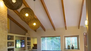 Amplia sala de estar con chimenea, un sofá grande, una mesa de centro y una estantería.