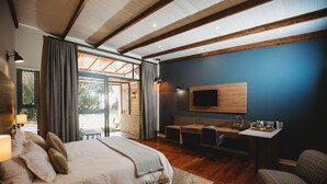 Un dormitorio moderno con una cama grande, un escritorio y un televisor.