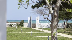 Un cementerio con lápidas blancas y una vista despejada del océano.
