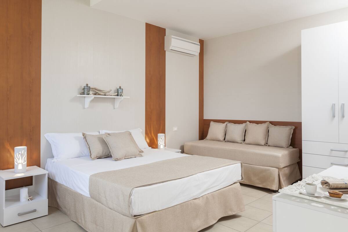 Um quarto moderno com duas camas, um guarda-roupa e uma mesa de cabeceira com abajur.