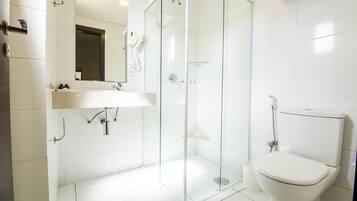 A modern bathroom with a glass-enclosed shower, a white sink, and a toilet.