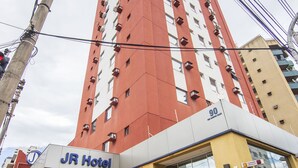 A tall hotel building with a red and white facade, labeled "JR Hotel" at the ground level. - JR Hotel (Ribeirão Preto)