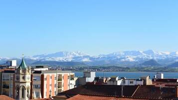Une vue d’une ville avec des bâtiments et, au loin, une chaîne de montagnes.