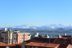 Vista de un pueblo con edificios y una cadena montañosa al fondo.