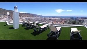 Eine Dachterrasse mit freiem Blick auf eine Stadt und Berge.