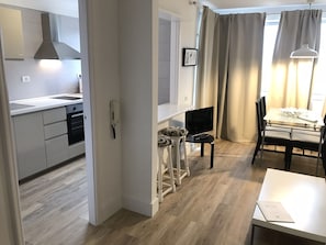Apartamento superior, 1 quarto | Área de estar | TV de tela plana