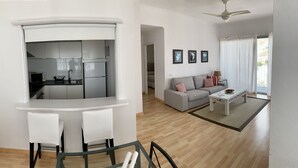 Ein modernes Wohnzimmer mit einer Couch, einem Couchtisch und einem Essbereich mit Stühlen und einem Tisch.
