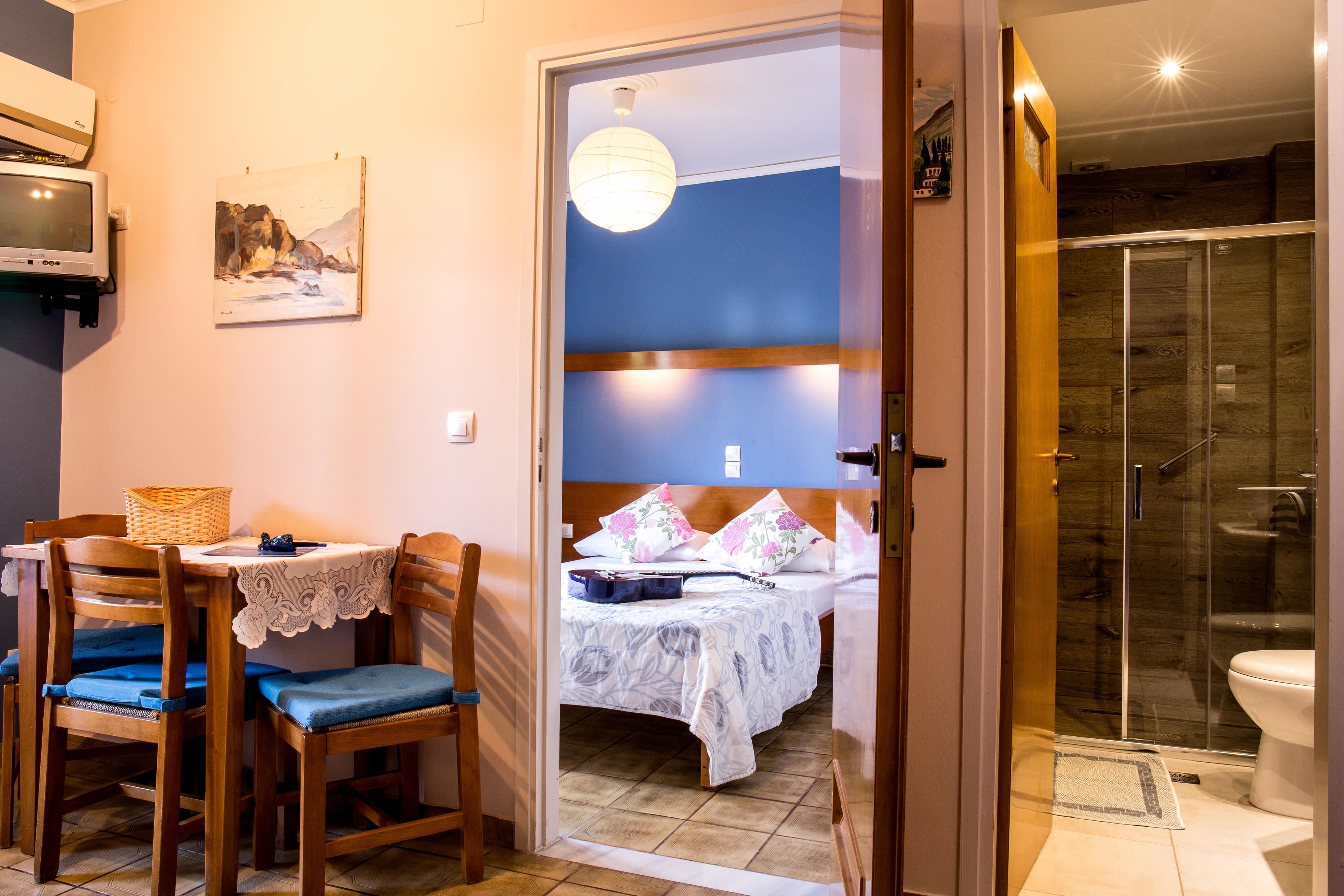 A bedroom with a bed, a bedside table, a chair, and a window.