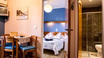 A bedroom with a bed, a bedside table, a chair, and a window.