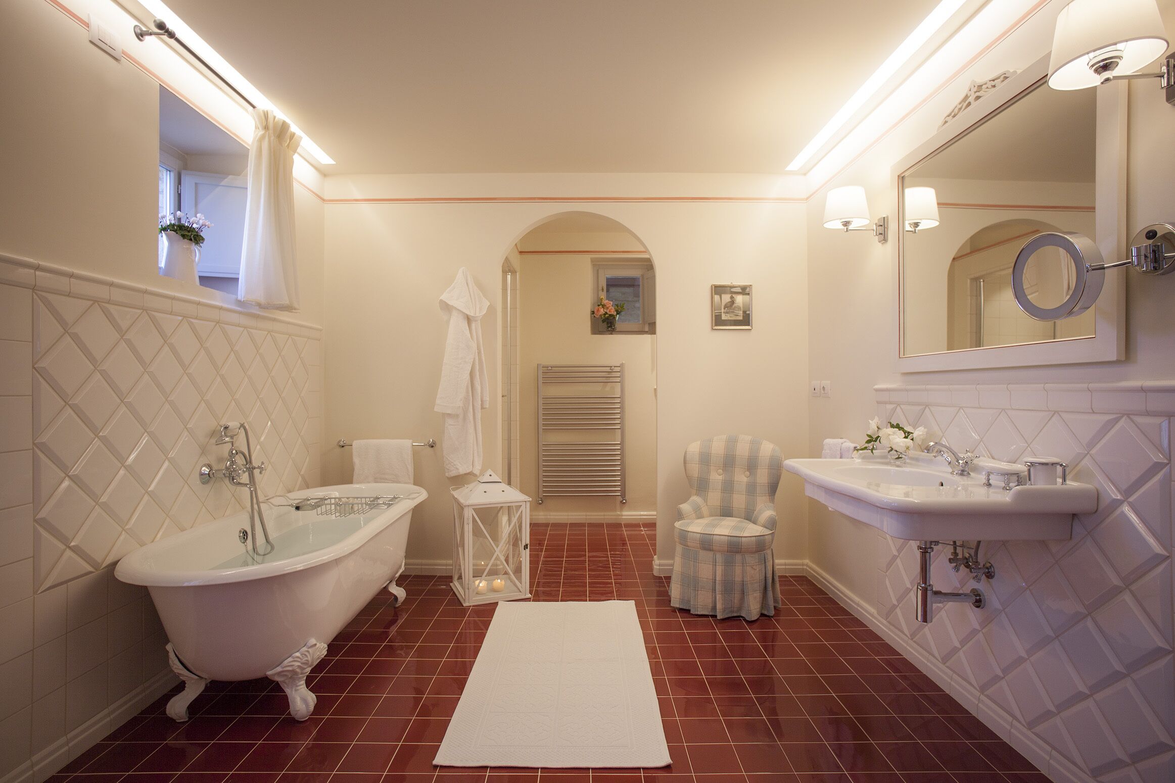 A bathroom with a freestanding bathtub, a sink, a mirror, and a towel rack.