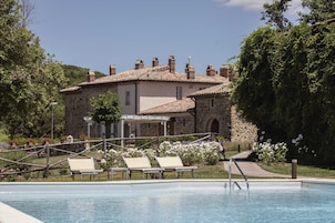Una piscina al aire libre, sillones reclinables de piscina