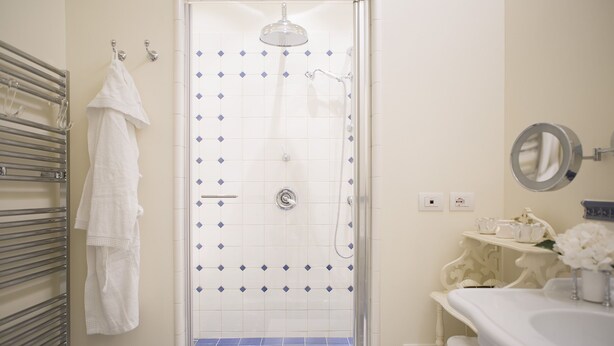 A bathroom with a shower, a towel rack, and a sink with a mirror. - Podere Brizio (Montalcino)