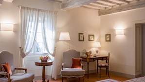 Una habitación con techo de madera, una mesa de comedor con sillas, una cama y una ventana con cortinas.