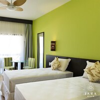 A hotel room with two beds, a small table, and chairs.