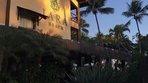 Un bâtiment portant l’enseigne « LARA BEACH » et surmonté d’une toiture en chaume.