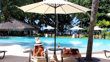 Een buitenzwembad, parasols voor strand/zwembad