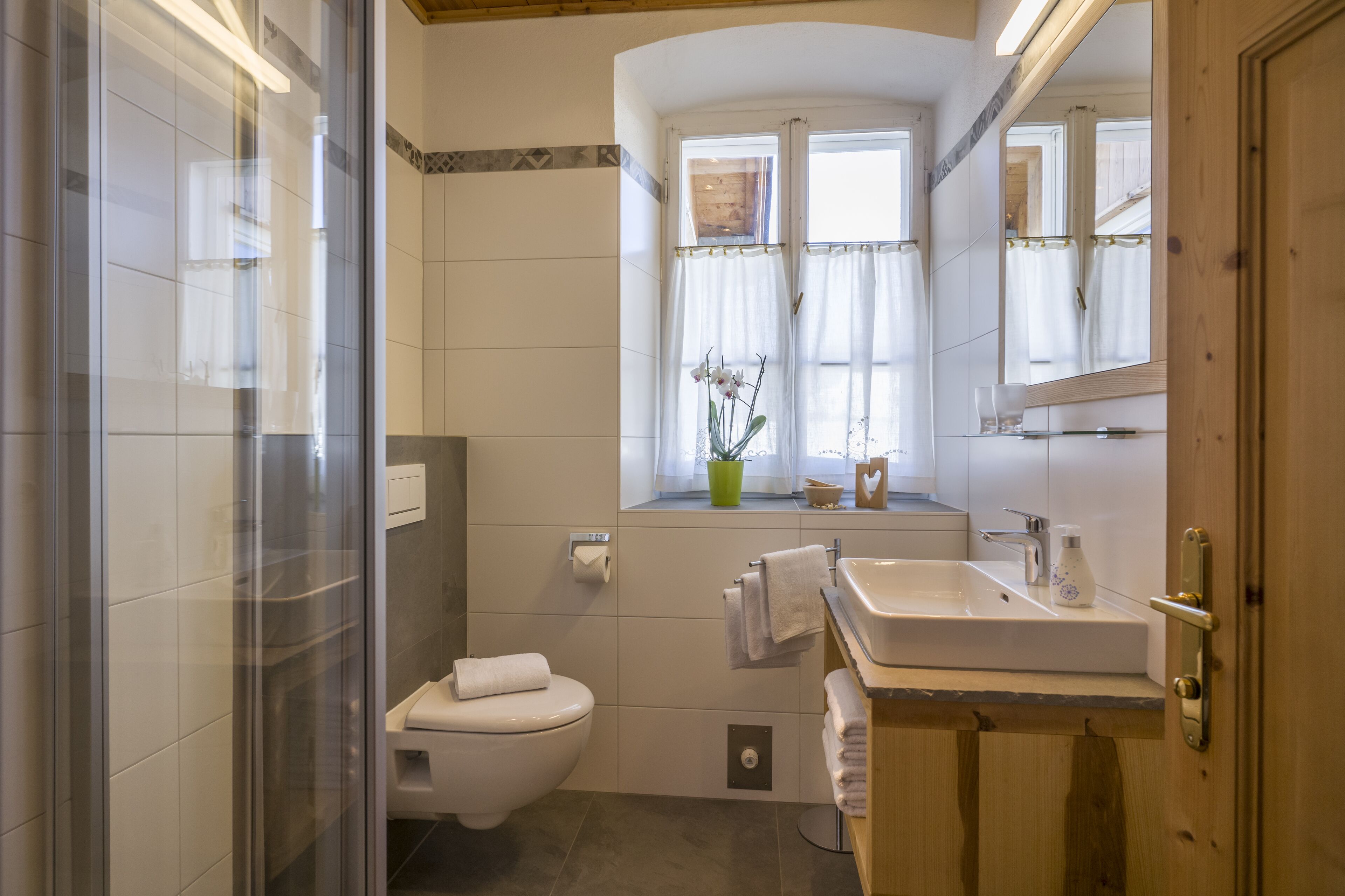 Ein modernes Badezimmer mit Toilette, Waschbecken und Spiegel.