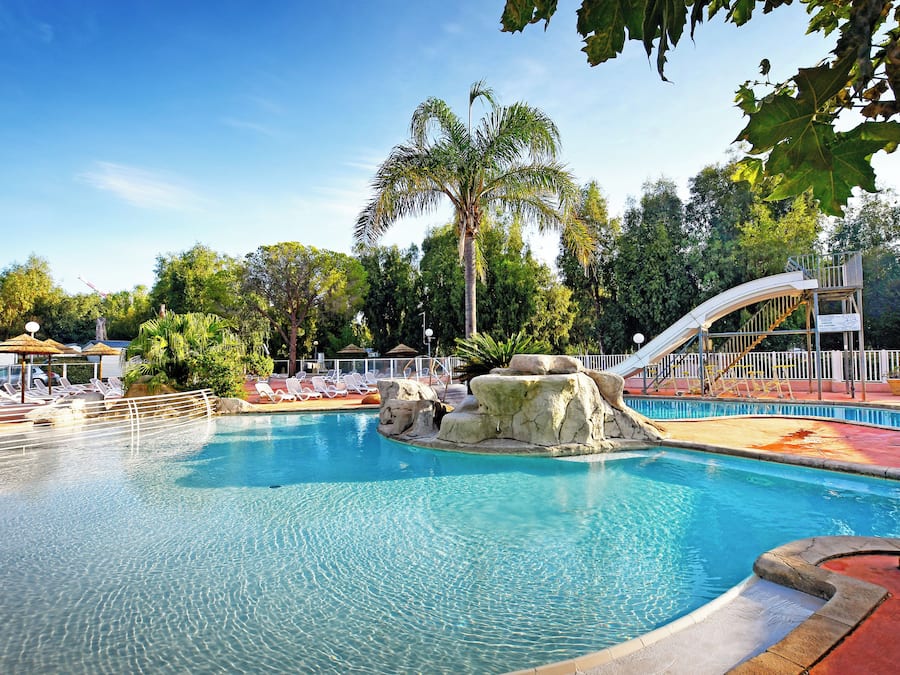 Una piscina al aire libre de temporada, sillones reclinables de piscina