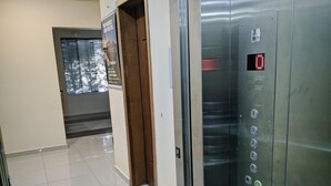 An elevator with a digital display and a metallic handrail. - Rede Andrade Biton (Foz do Iguaçu)