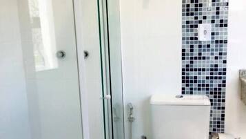 Un baño moderno con cabina de ducha de vidrio, inodoro y bidé.