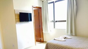 A hotel room with two beds, a TV on the wall, and a window with curtains. - Rede Andrade Biton (Foz do Iguaçu)
