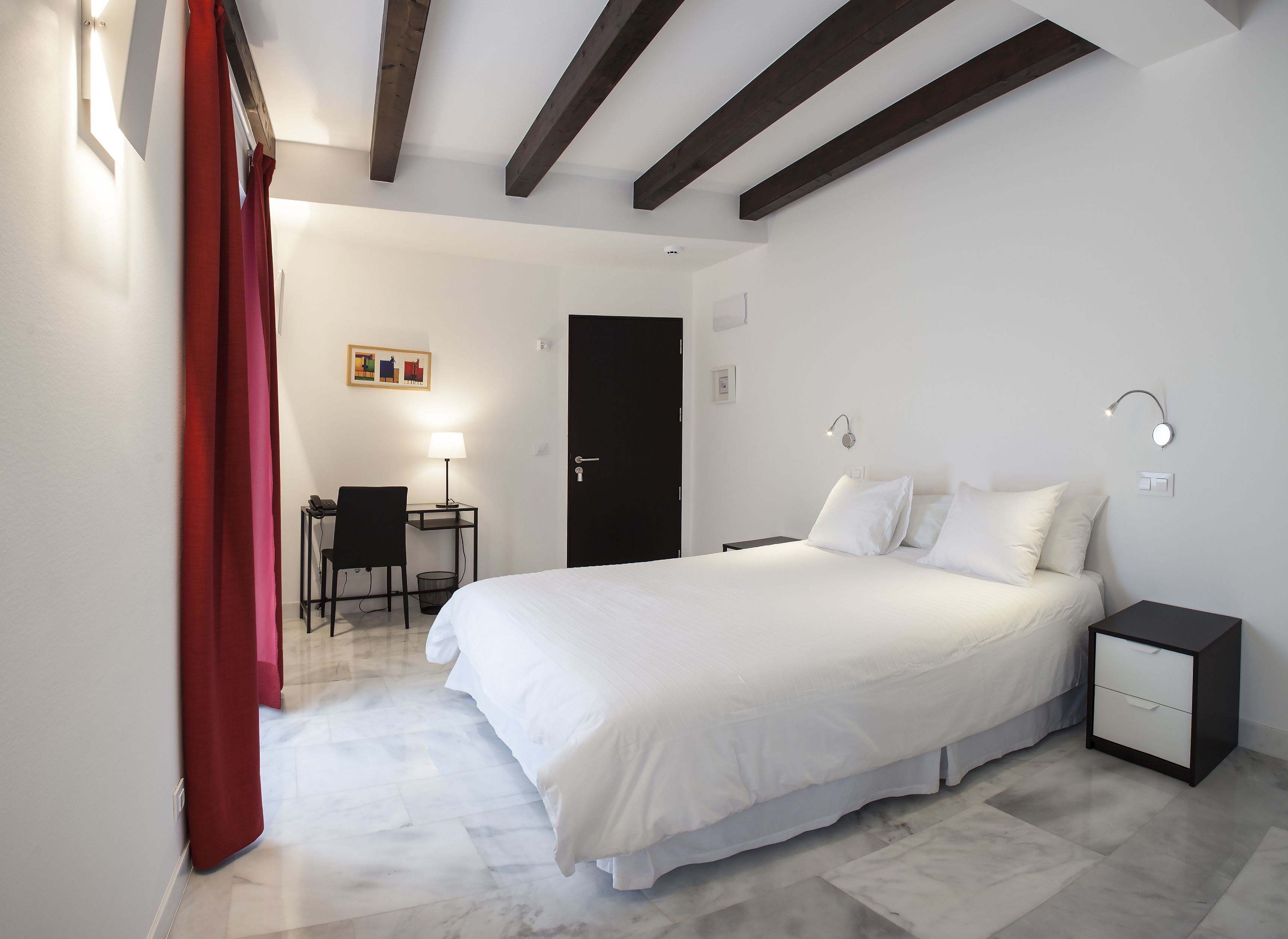 Una habitación de hotel moderna con una cama grande, un escritorio y una silla.