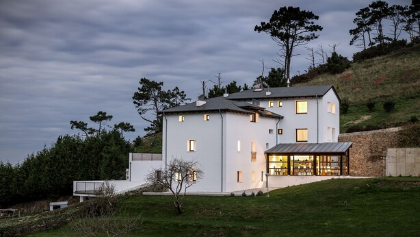 A modern two-story house with a flat roof, large windows, and a visible interior. - Finca Portizuelo (Valdes)