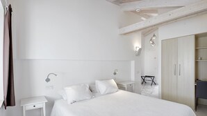 A minimalist bedroom with a large bed, bedside tables, a wardrobe, and a small desk. - Finca Portizuelo (Valdes)