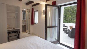 A bedroom with a large bed, a wardrobe, a desk, and a balcony with outdoor furniture. - Finca Portizuelo (Valdes)