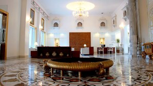 A spacious lobby with a grand chandelier, ornate columns, and a patterned floor. - Pratap Mahal, Ajmer - IHCL SeleQtions (Pushkar)