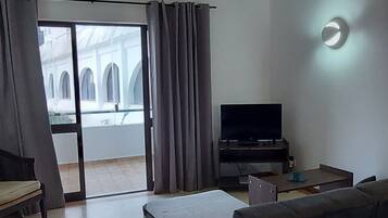 Departamento estándar, 2 habitaciones, cocina, vista a la alberca | Área de sala de estar | Televisión de 46 cm con canales por cable