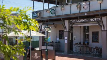 The Corner Hotel with outdoor seating and a signboard.