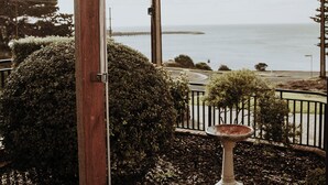 A wooden door with a showerhead, a birdbath, and a view of the sea. - Baudin House (Penneshaw)