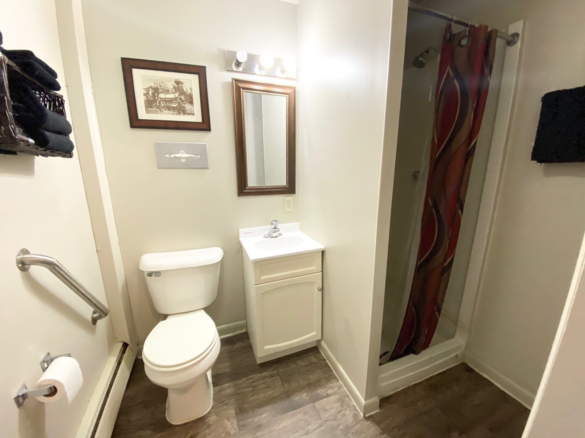 A bathroom with a toilet, sink, and shower.