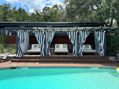 Una piscina al aire libre, sillones reclinables de piscina