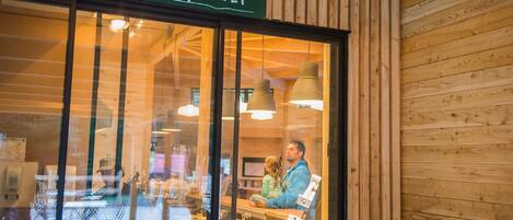 A restaurant with a wooden interior and a sign reading "Pizzas à Emporter".