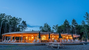 A wooden lodge with outdoor seating and a covered patio area.