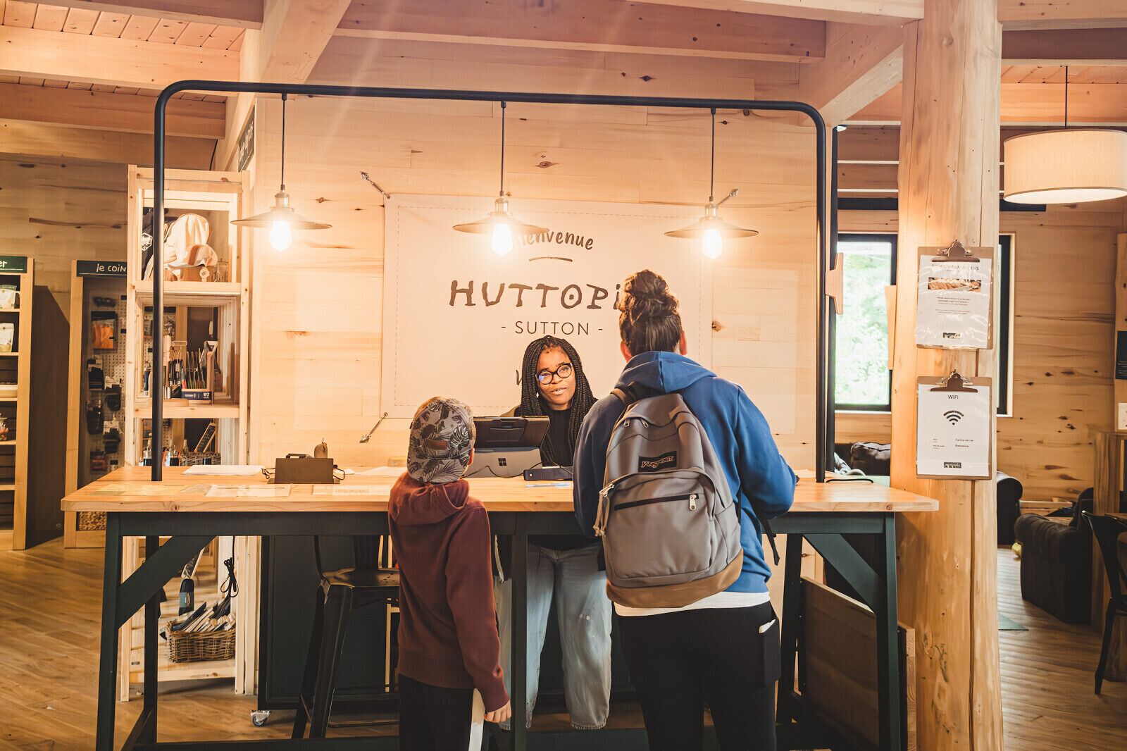 A wooden interior with a counter labeled "HUTTOPI - SUTTON" and a sign indicating WiFi availability.