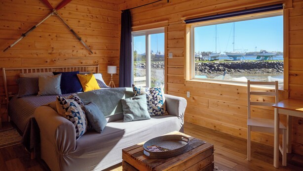 Un chalet confortable avec un lit, un canapé et un coin repas.
