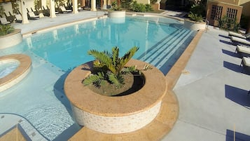 Una piscina al aire libre, sillones reclinables de piscina