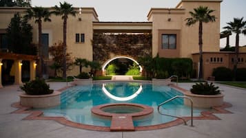 Una piscina al aire libre, sillones reclinables de piscina