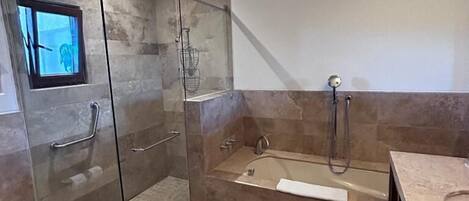 A modern bathroom with a glass-enclosed shower, a freestanding bathtub, and a vanity with a countertop.