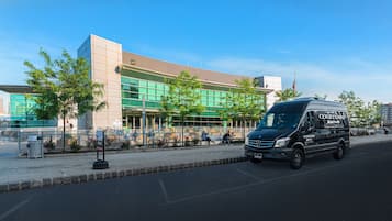 Ein Courtyard Marriott Hotel mit moderner Glasfassade, einem Parkplatz und einer Straße mit Fußgängern.