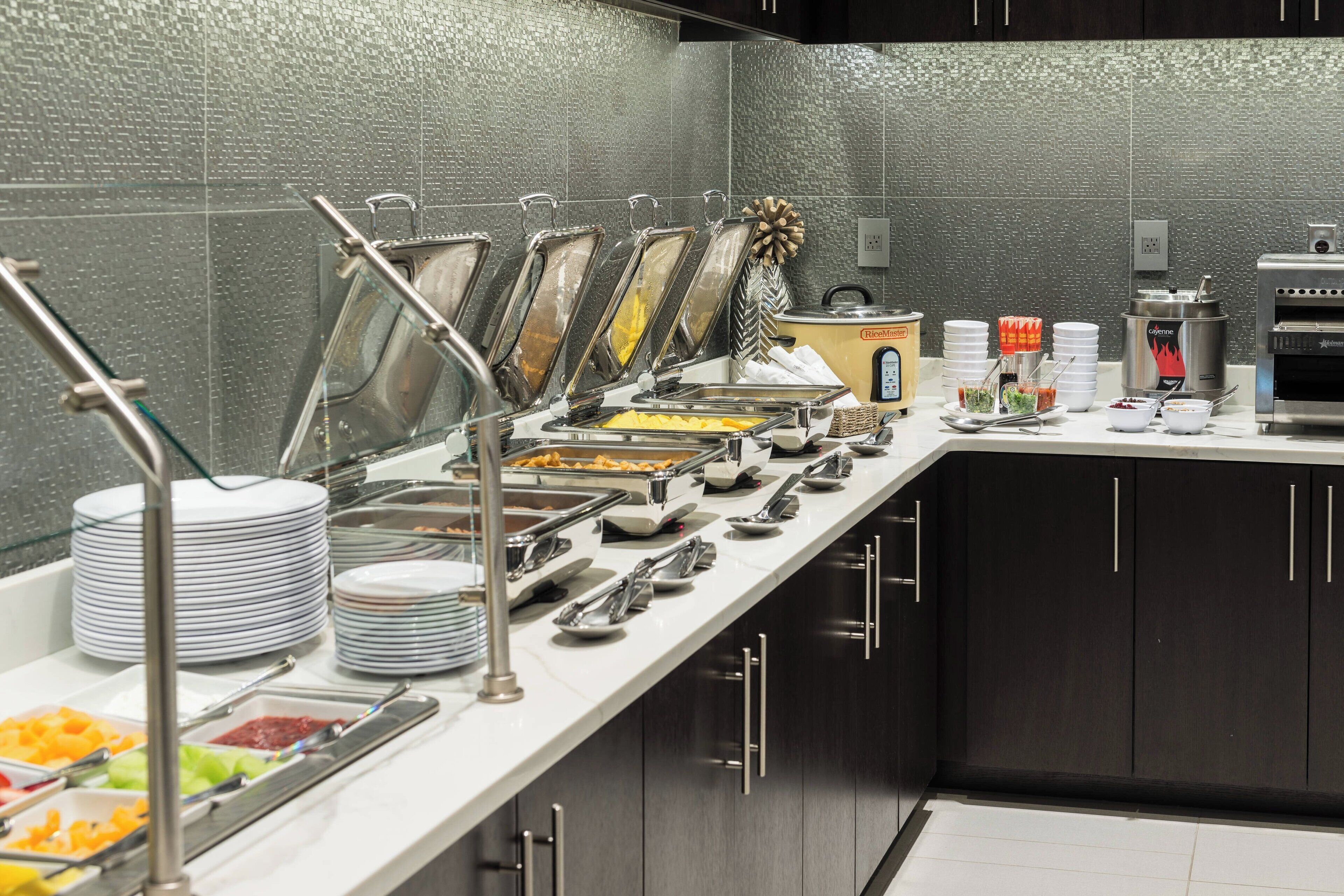 A buffet setup with various food stations, including a hot food station, a salad bar, and a beverage station.