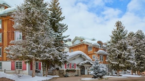 A large wooden building with snow-covered trees and a clear sky. - Christiania Condominiums - Residence Collection (Vail)