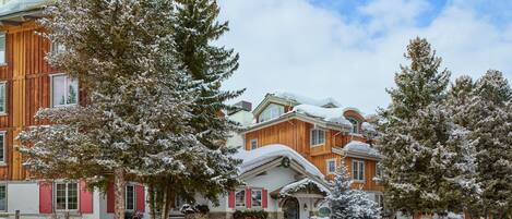 Un edificio de madera grande con árboles nevados y un cielo despejado.