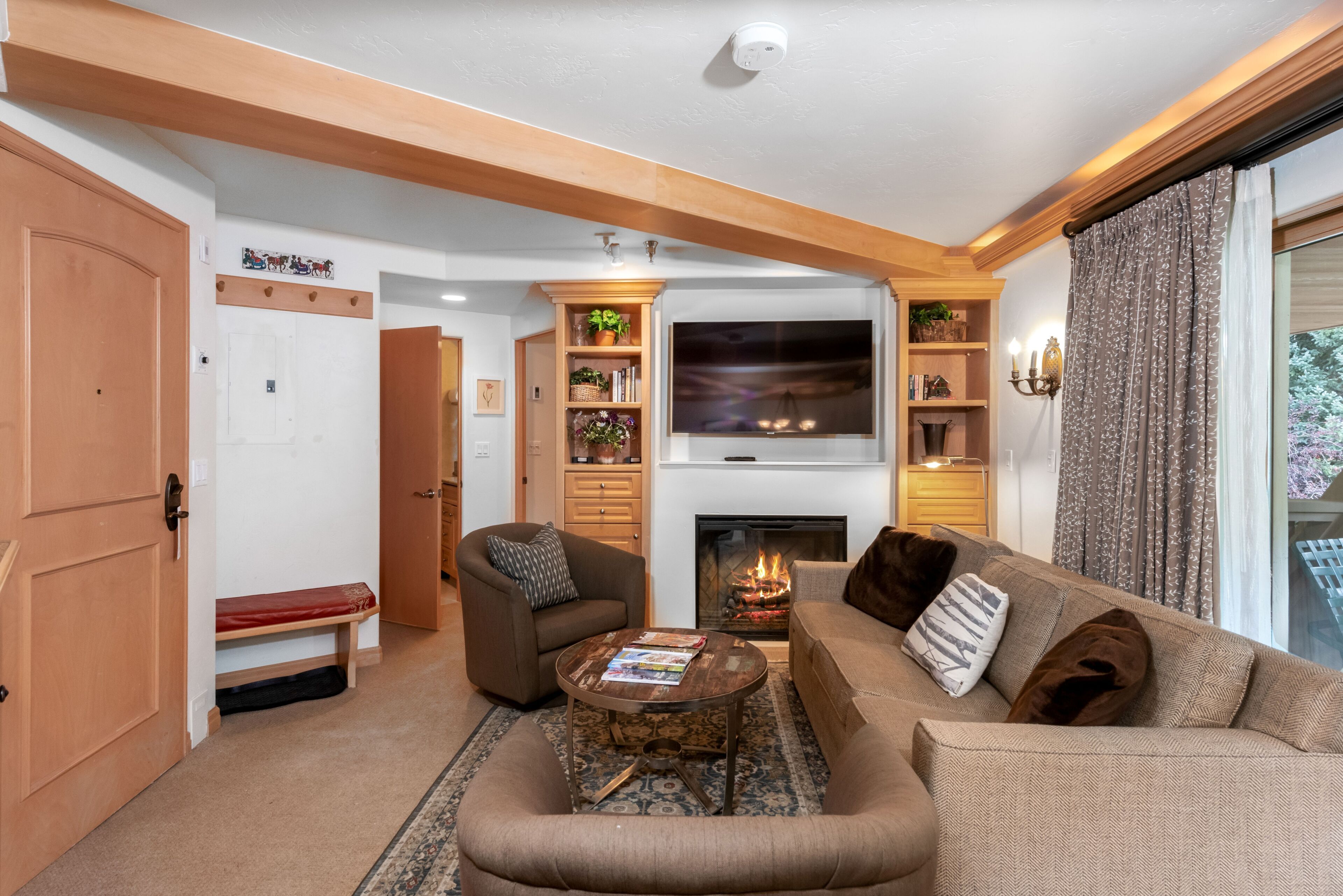 Un salon chaleureux avec une cheminée, des fauteuils confortables et un téléviseur.