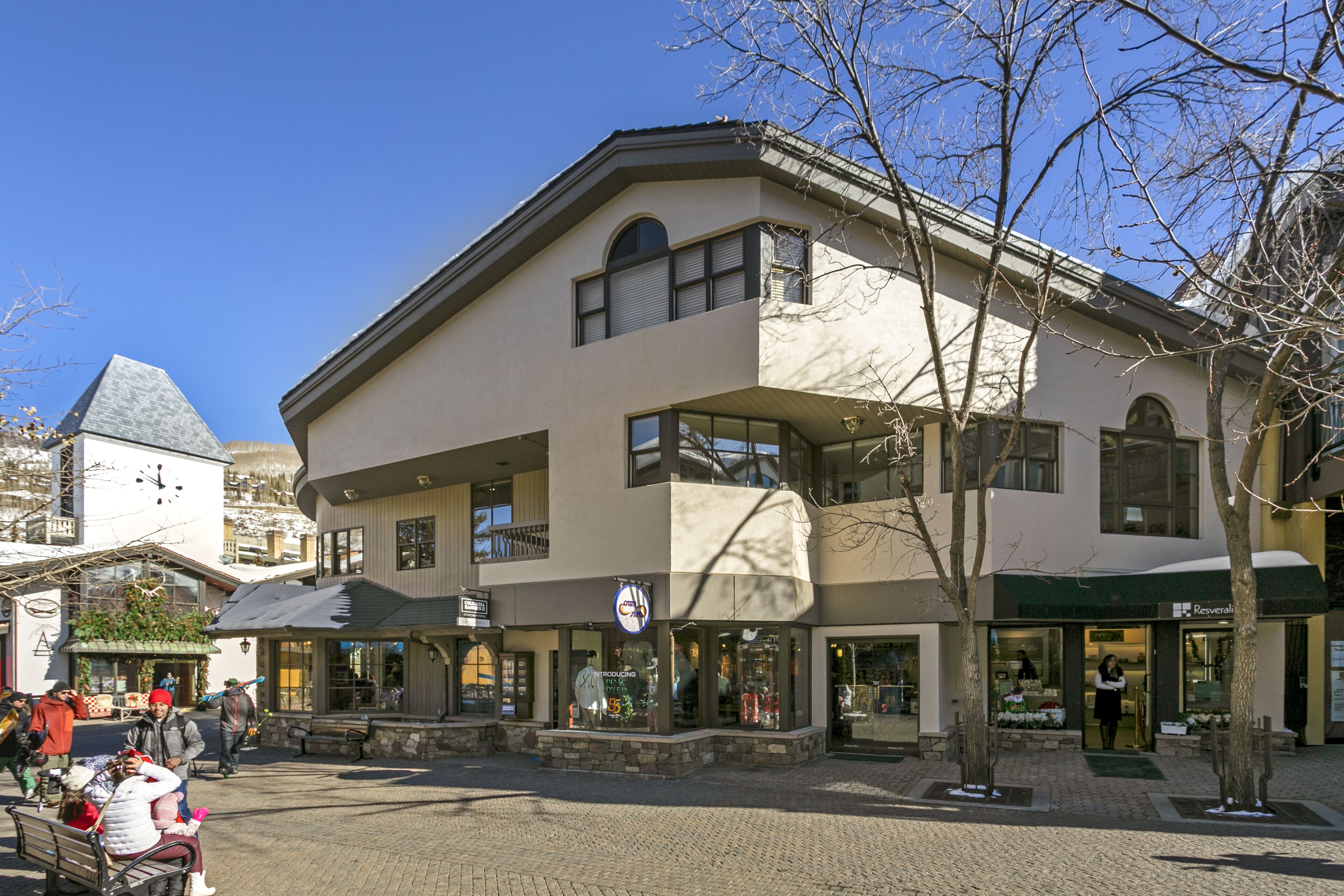Un edificio de varios pisos con una tienda en la planta baja y espacios residenciales o comerciales en los pisos superiores.