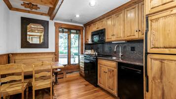 A kitchen with wooden cabinets, a microwave, a stove, and a sink.