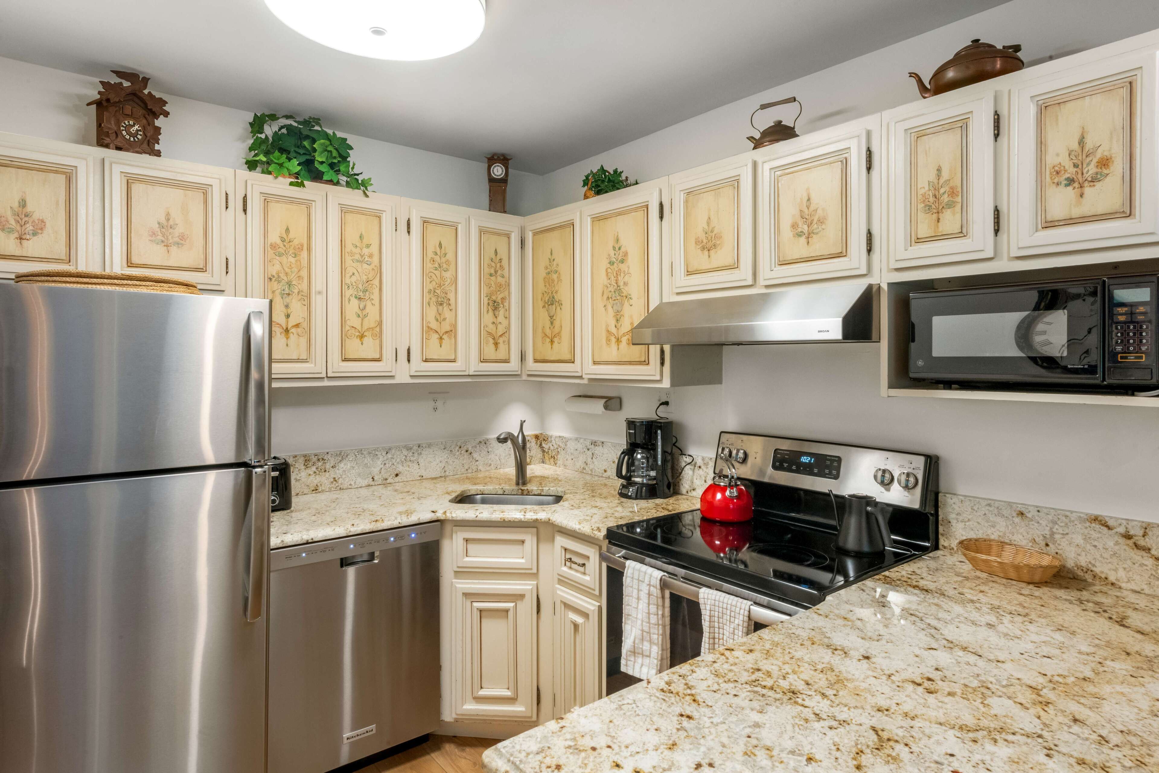 A kitchen with white cabinetry, stainless steel appliances, and a granite countertop.